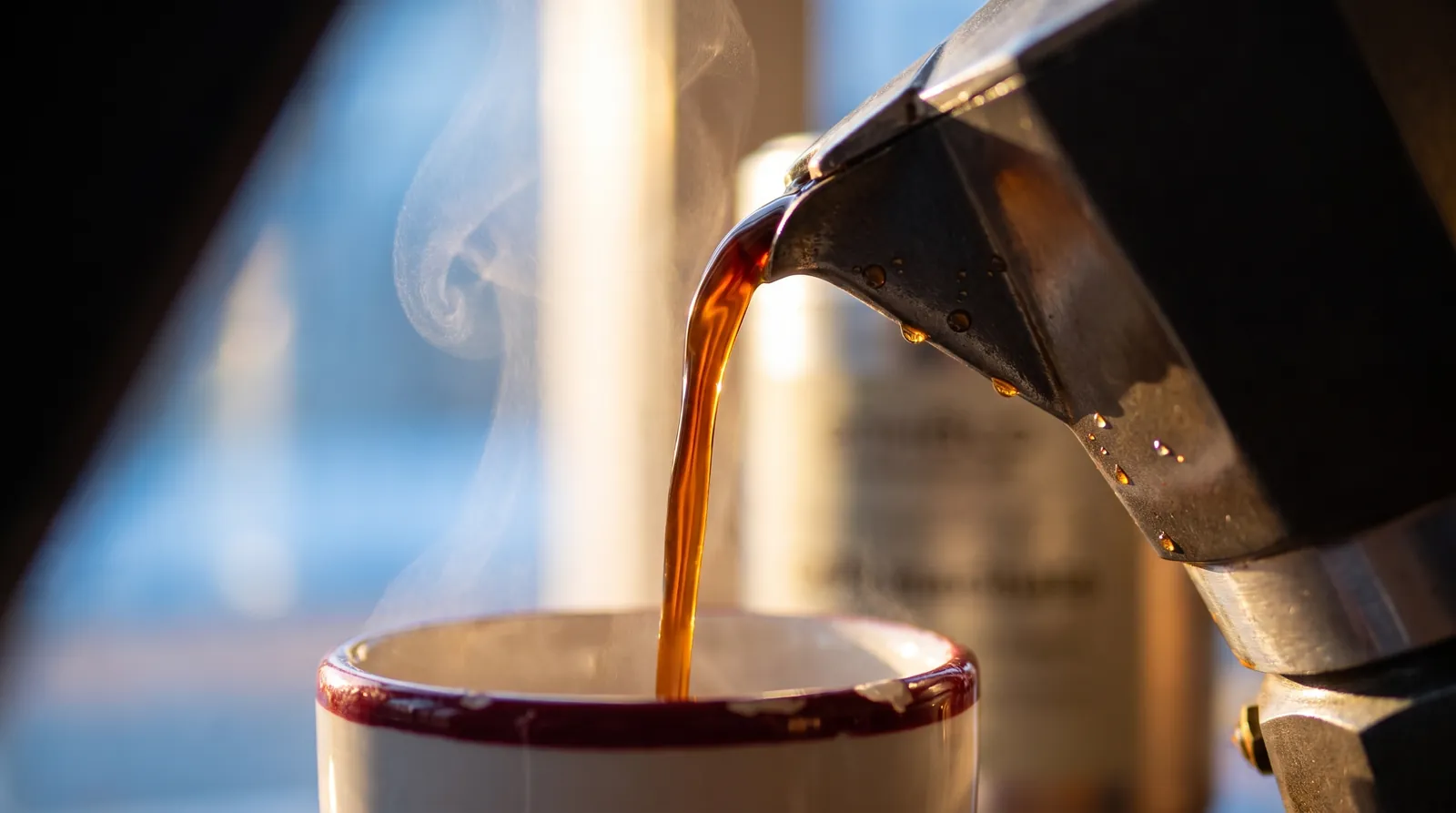 Coffee flowing from a moka pot into a cup