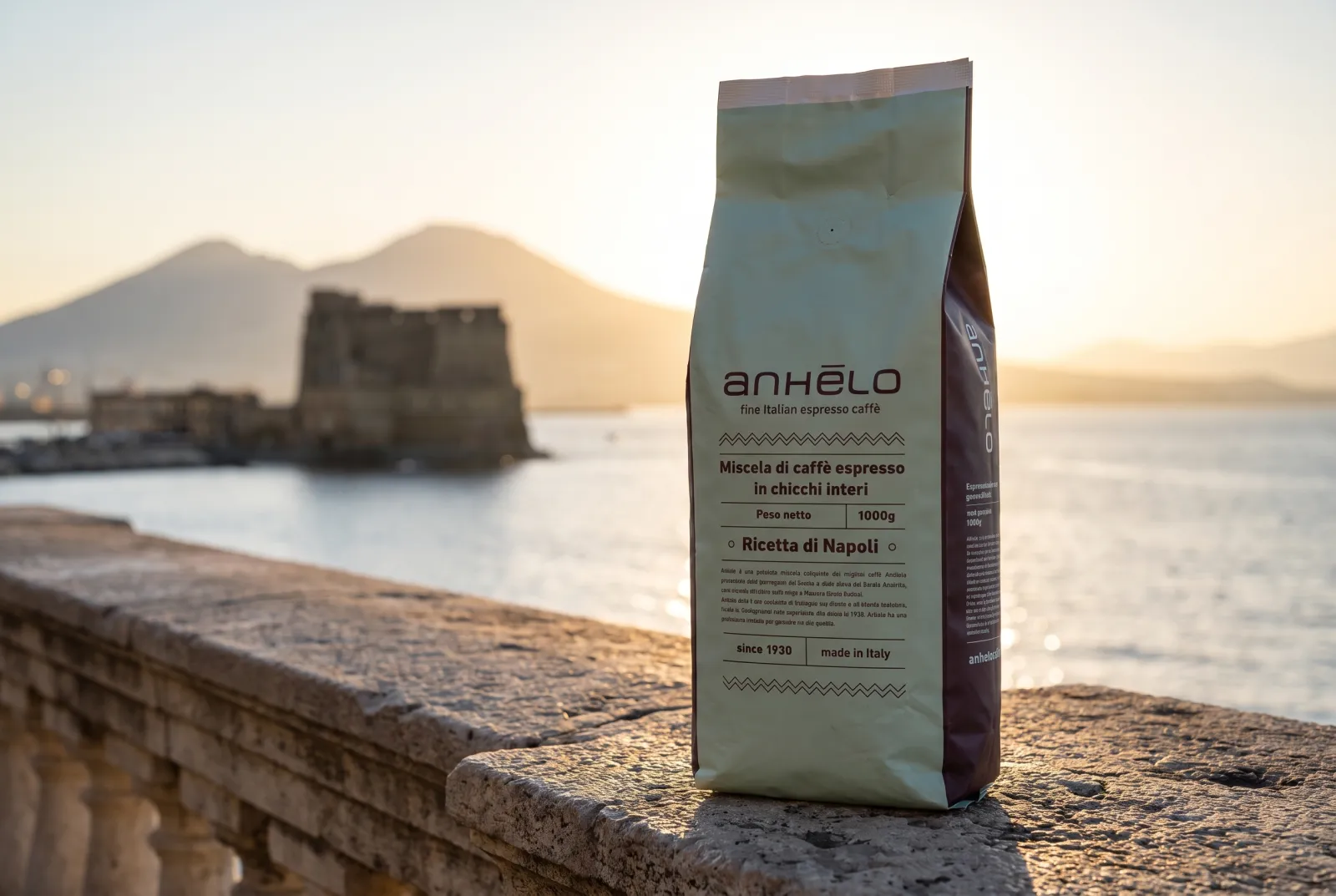 Anhelo whole beans 1000g pack on a stone parapet by the sea, with Vesuvius in the background