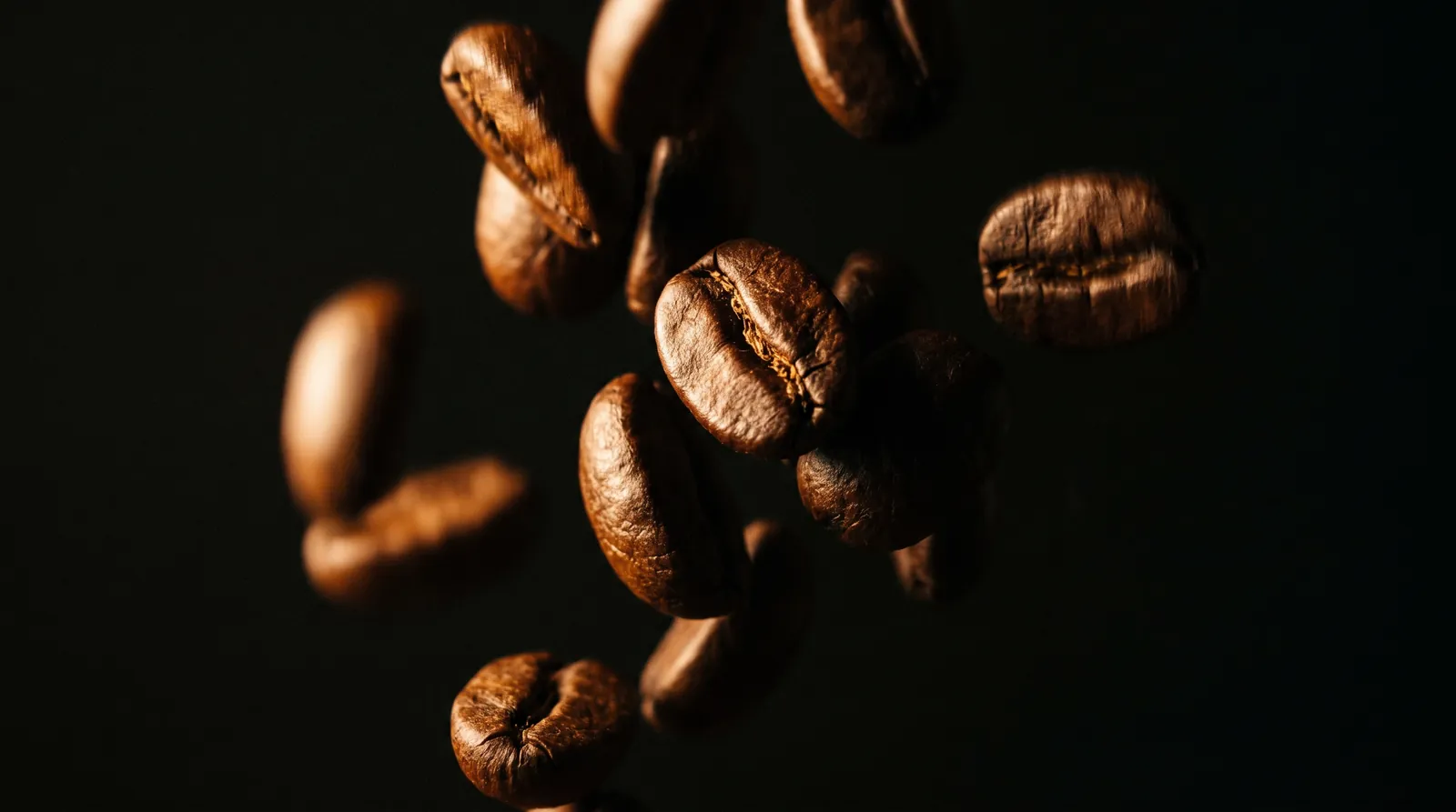 Coffee beans flying against a dark background