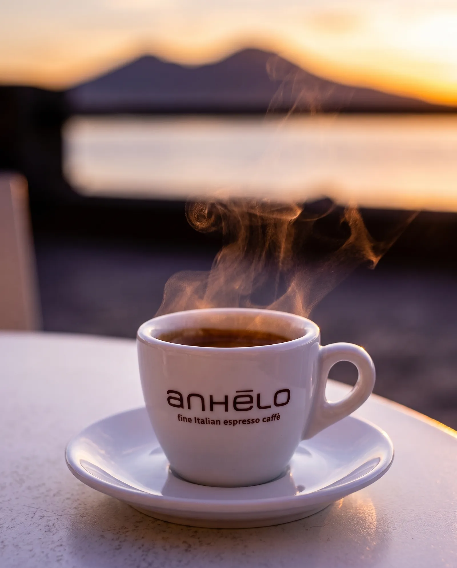 Steaming Anhelo cup with Vesuvius at sunset in the background